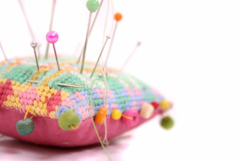 Pin cushion with pins sticking out.
