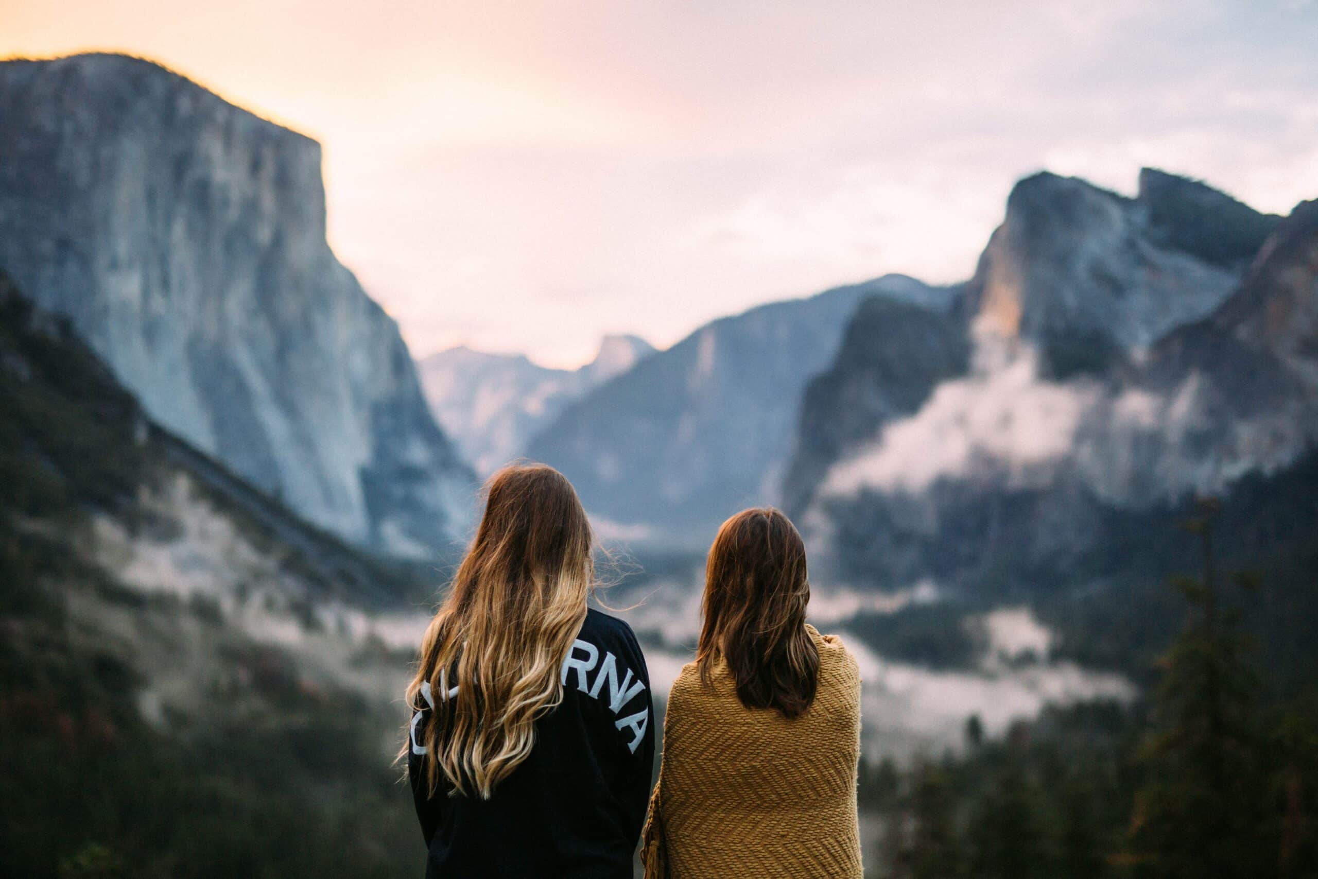 Two women looking at rocky mountainside.
