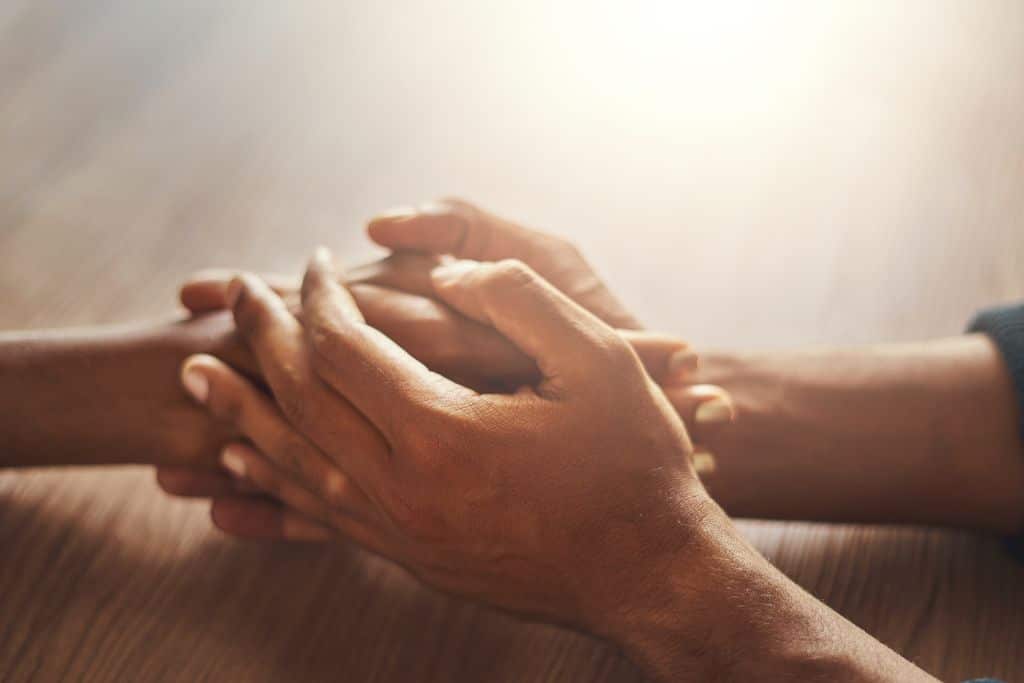 Hands holding on a table.
