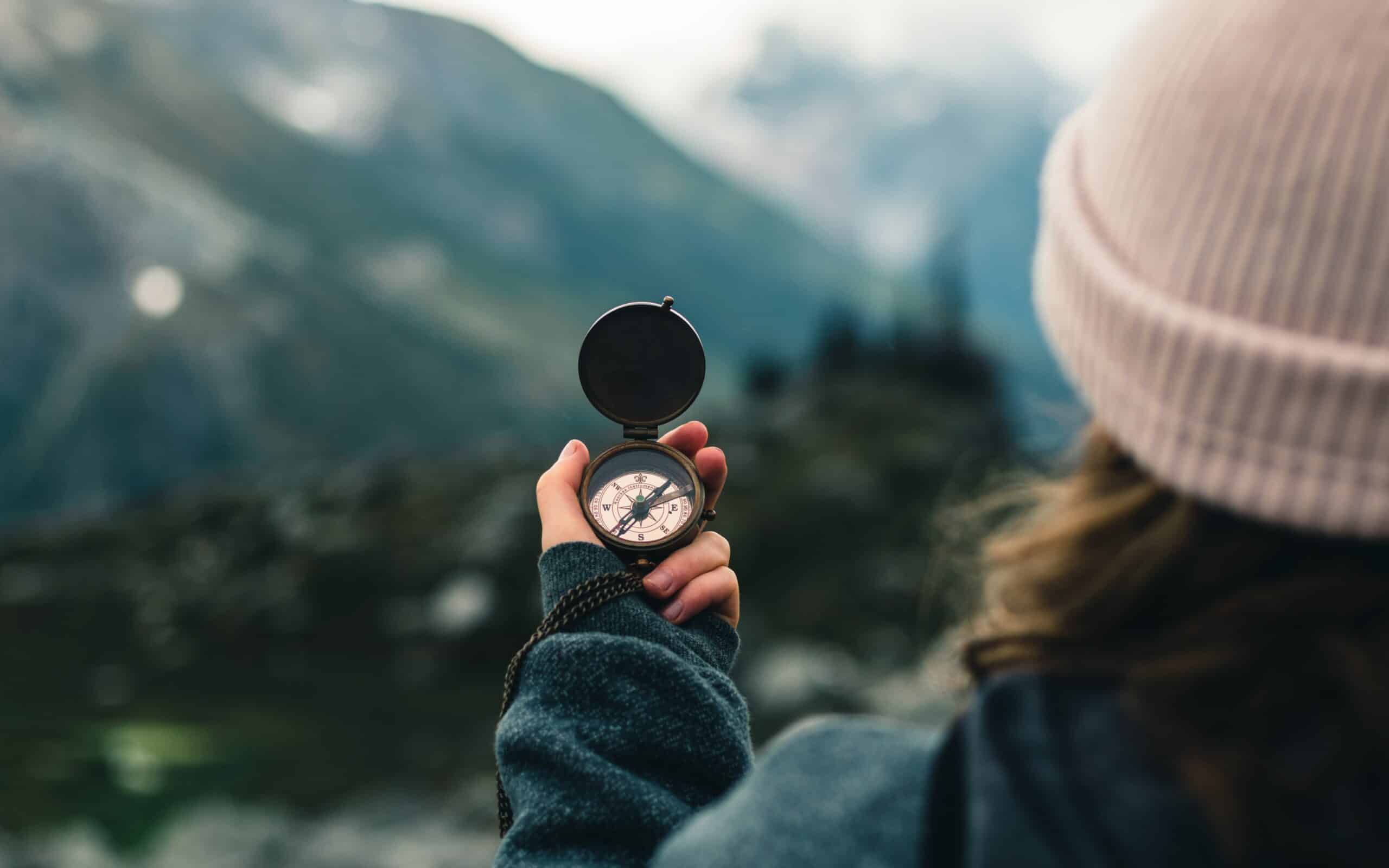 Woman holding compass in nature.