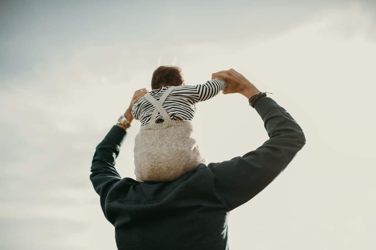 Man holding child on shoulders.