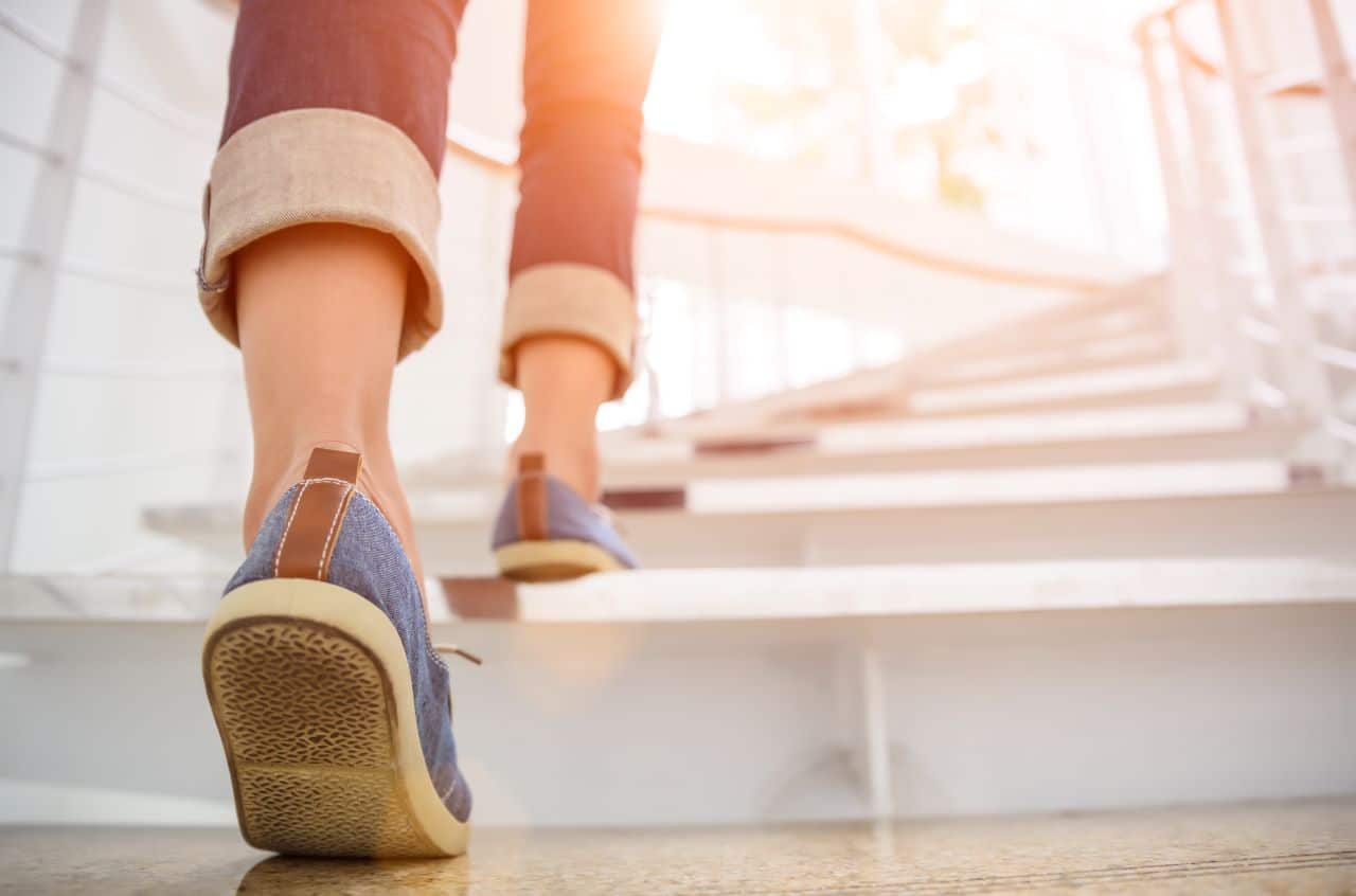 Portrait of the back of a woman's shoes while she is walking upstairs.
