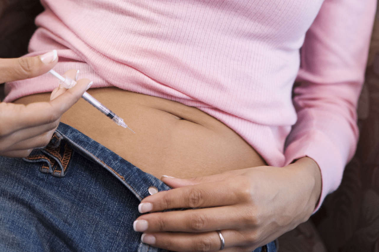 Woman giving herself IVF medication shot