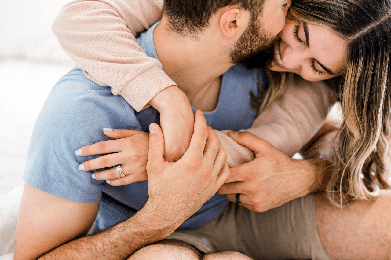 a heterosexual couple hugging and kissing eachother