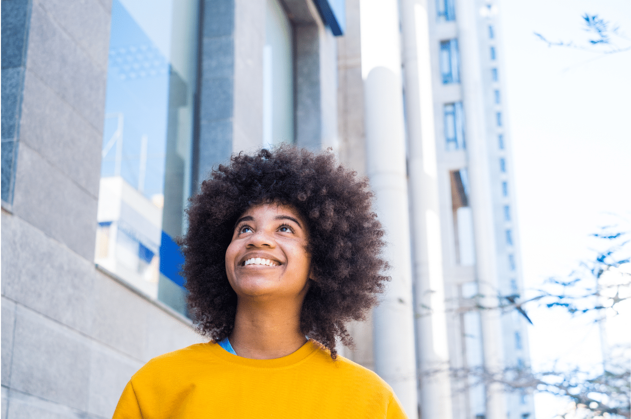 a woman with an afro walking down a city street