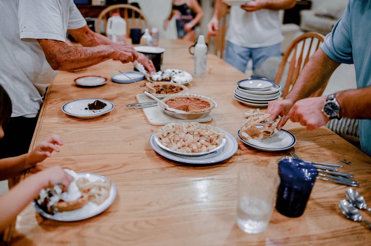 Several people fixing their plate at a dinner table