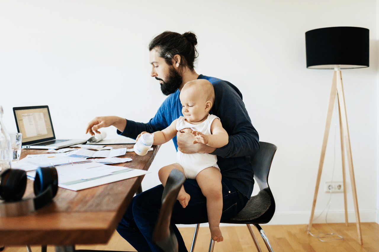 Photo of a man sitting at a desk with laptop and papers
