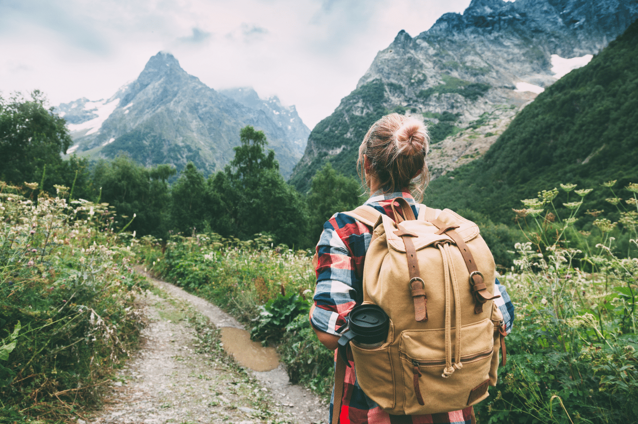 Photo of a hiker with a backpack looking at mountains