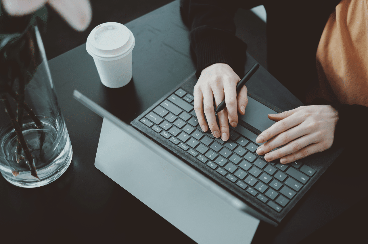 Photo of a person's hands typing on a tablet keyboard.