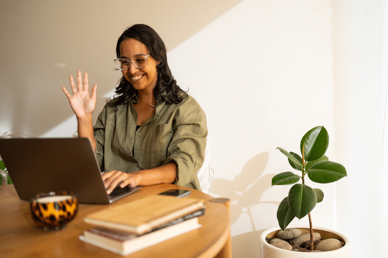Photo of a woman sitting at a table in front of a laptop