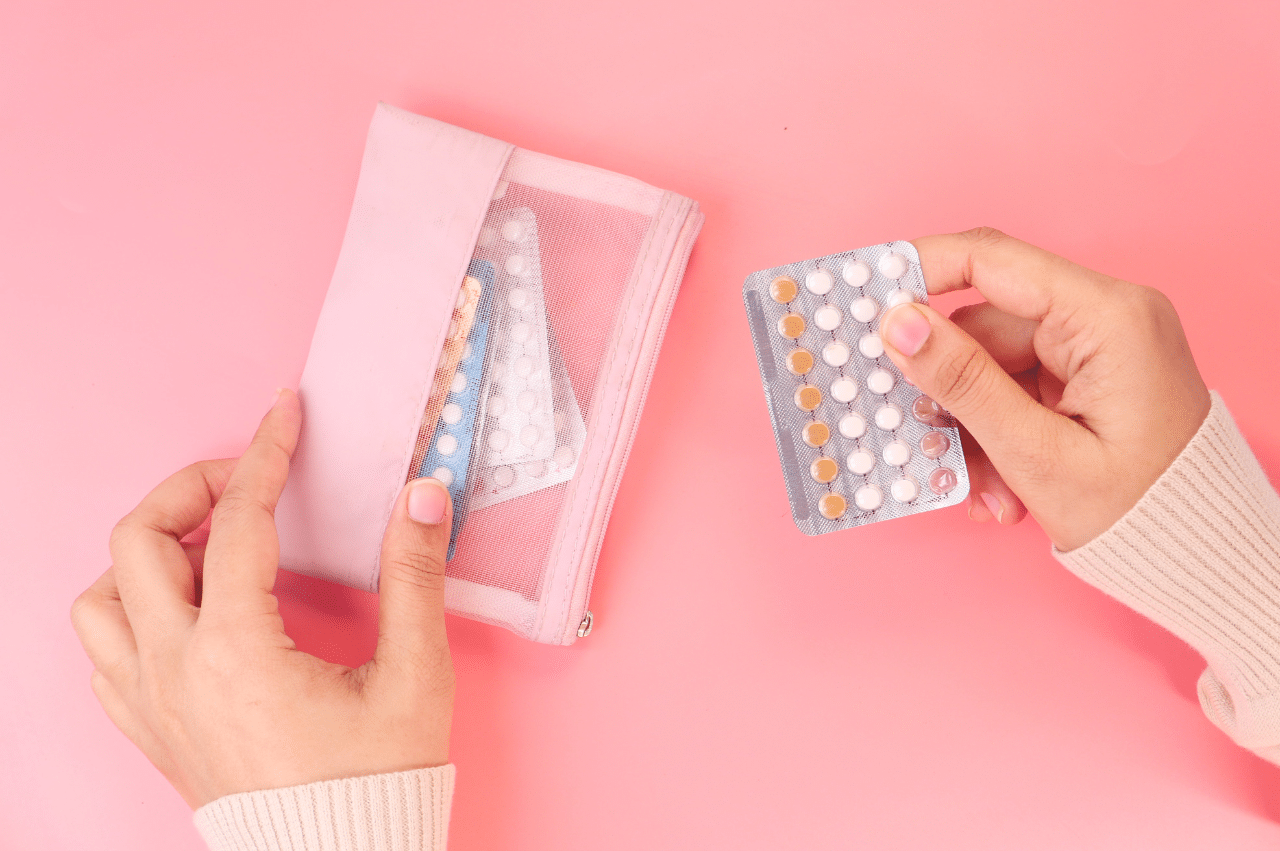 Photo close up of hands holding birth control pills