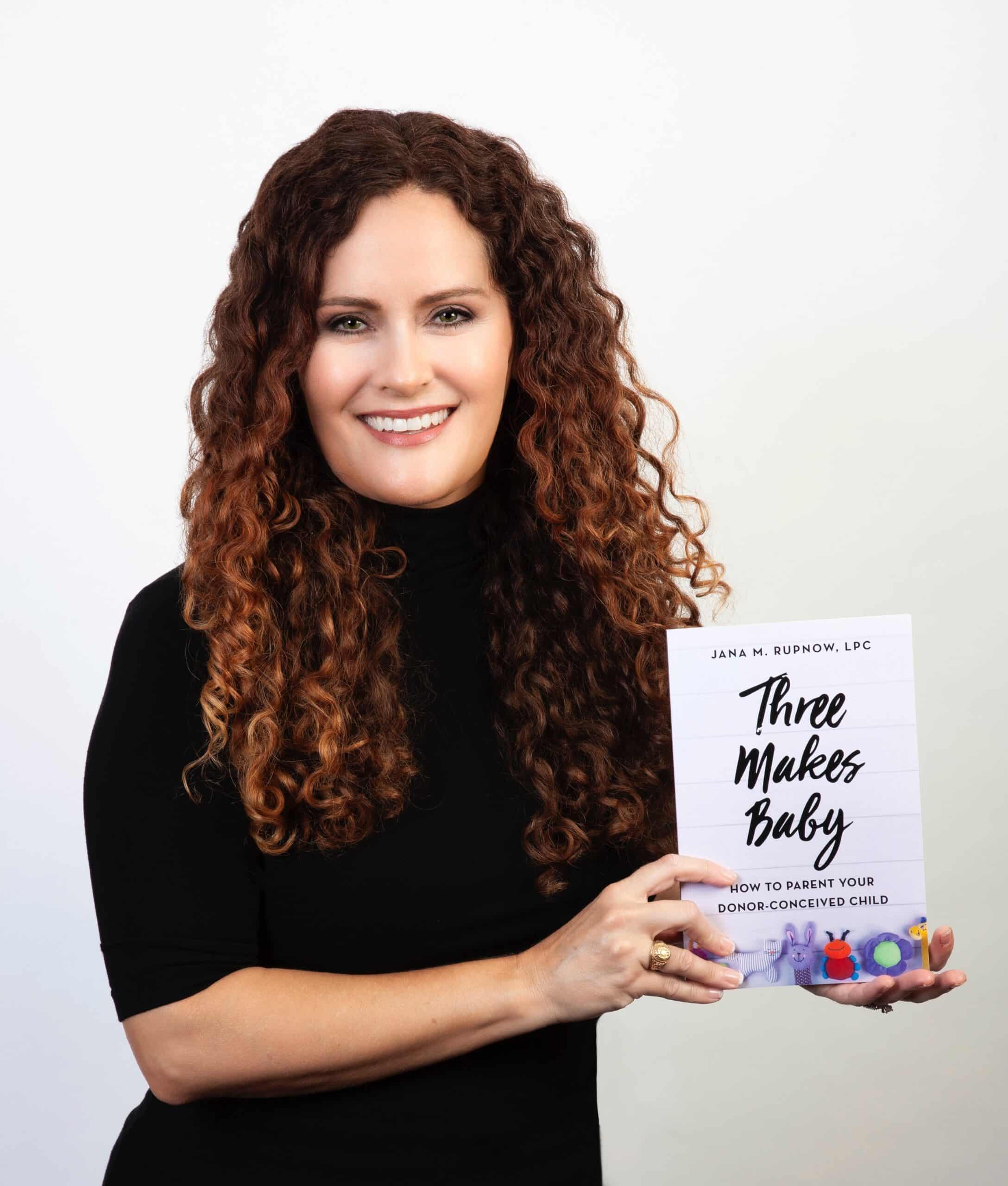 Headshot of Jana Rupnow holding her book "Three Makes Baby"