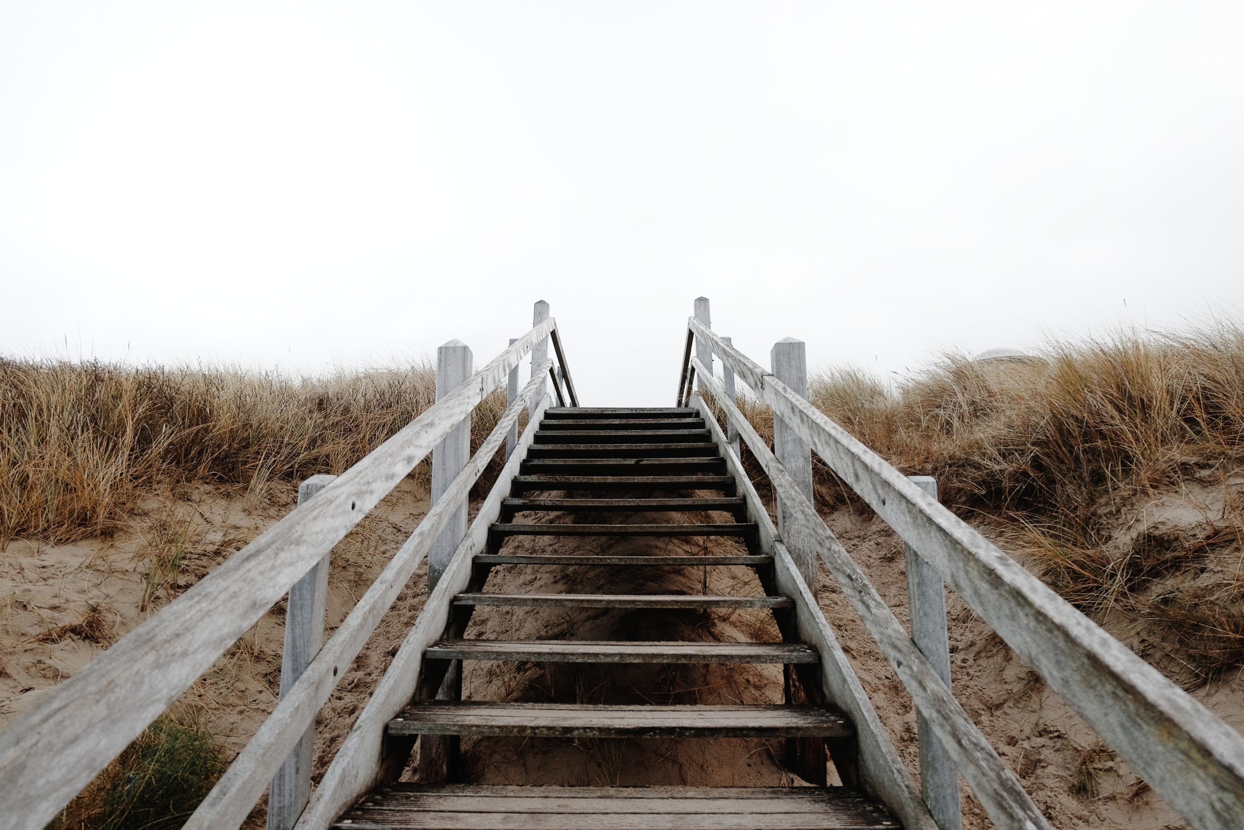 Bottom of wooden stairwell on the beach looking up.